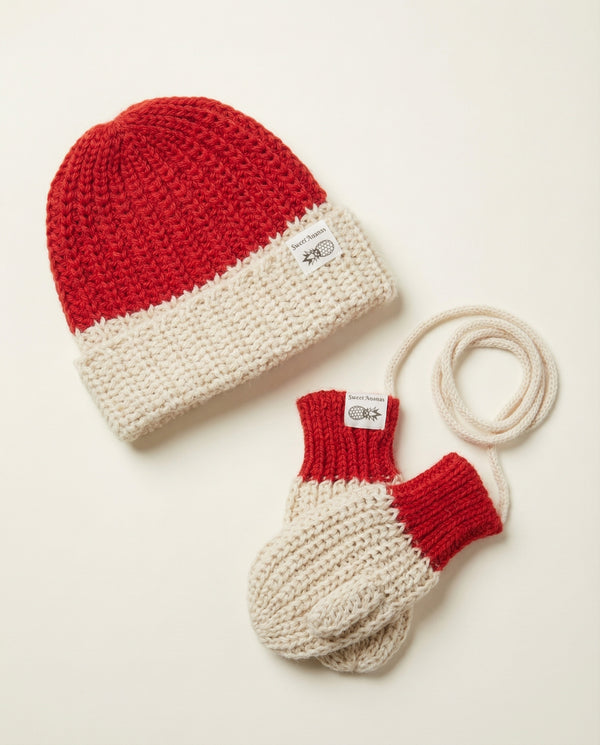 Red and beige knit hat and mittens set on a light background